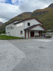 Fotografi av en eksisterende bygning (Jotunhuset) sett fra utsiden, med omgivelsene i bakgrunnen.