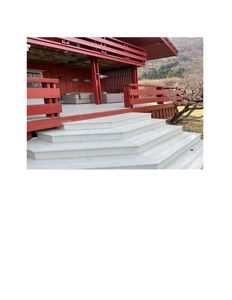 Fotografi av en rød bygning med trapp og veranda.