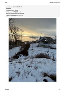 Et fotografi av en bygning (sannsynligvis en hytte eller bryggehus) sett fra bakken, med snø på bakken og vann i bakgrunnen.