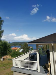 Fotografi av en terrasse med utsikt over en fjord og nabolag.
