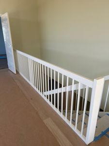 Fotografi av en trapp med hvit balustrade og trinnbeskyttelse under oppussing.