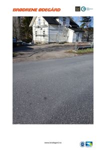 Fotografi av en hvit villa under oppussing eller vedlikehold, med stålrekkverk og en del av en vei i forgrunnen.