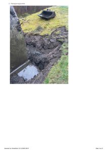 Fotografi av en gravd ut grøft eller grøfting på et byggefelt, med en grøfteskovl i bakgrunnen.