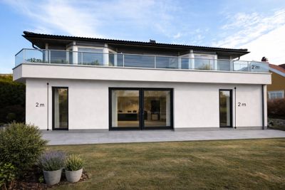 Fotografi av en moderne toetasjes bygning sett fra fronten, med mål angitt på fasaden.