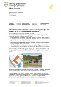 Fotografi av en eksisterende bygning (verksted) med et planlagt tilbygg (rødt) markert på en situasjonsplan i bakgrunnen.