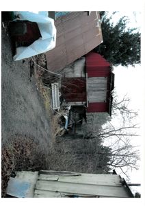 Fotografi av en eksisterende bygning (gjerne en uthus eller garasje) sett fra siden.