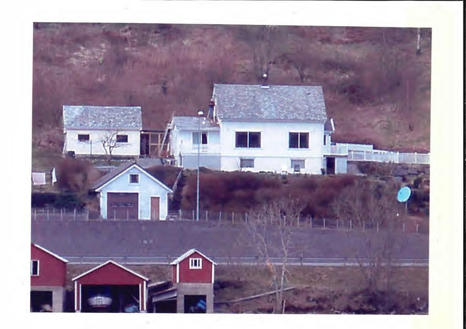 Fotografi av en eksisterende boligbebyggelse på en skråning, sett fra nede.