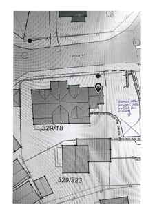 Situasjonsplan som viser tomtene 329/18 og 329/323, nabobebyggelser, vei (Vandugveien) og håndskrevne notater om garasjeanlegg.
