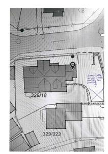 Situasjonsplan som viser tomtene 329/18 og 329/323, nabobebyggelser, vei (Vandugveien) og håndskrevne notater om garasjeanlegg.