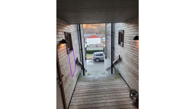 Fotografi av en utendørs trapp og en gangvei mellom to trehus.