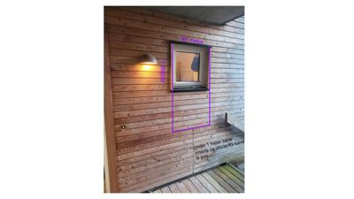 Fotografi av en fasade med trepanel, et vindu og en vegglampe. Bildet inneholder også digitale merkelinjer og tekst som indikerer en måling eller en teknisk notat.