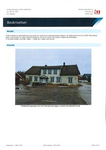 Fotografi av en bygning (hus) sett fra foran, med tilstøtende bygninger og parkeringsplass.