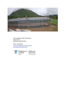 Fotografi av en bygning under oppføring med takkonstruksjon og stålramme, sett fra et høyere nivå.