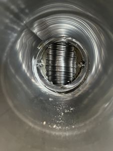 Fotografi tatt inni en ventilasjonsrørledning (tynn) som viser en kobber-rørledning (tykk) som er festet inn i den.