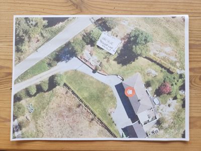 Flyfoto eller luftfoto av eiendom med hus, vei og omgivelser.