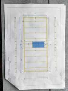 Konstruksjonstegning som viser et tverrsnitt av en bygning med bjelkelag og en blå farget romdeling.