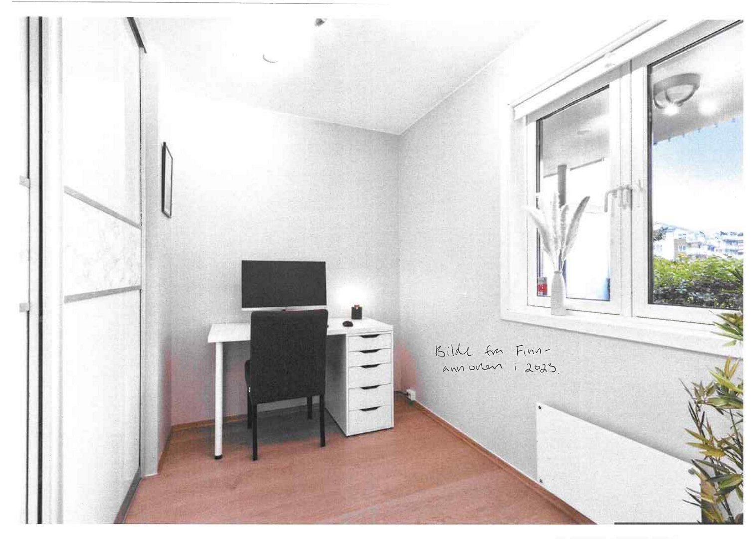 Fotografi av et innredet rom (stue/kontor) med skrivebord, stol og vindu.