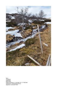 Fotografi av et terreng med snø, en liten bekke og en gjerdekonstruksjon.