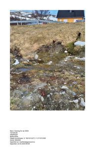 Fotografi av en graving for rør med en bygning i bakgrunnen