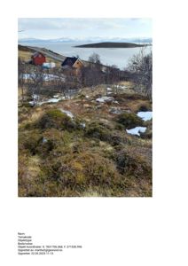 Fotografi av et landskap med hus, hav og fjell i bakgrunnen.