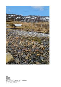 Fotografi av et landskap med en grusbekk i forgrunnen, en hekk og snødekte bakker i bakgrunnen.