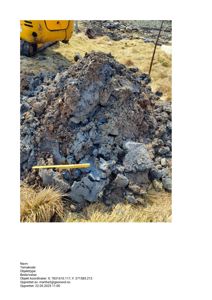 Fotografi av en grøft eller utgravet masse på et byggefelt, med en gullgul målestokk i forgrunnen.