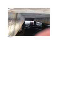 Fotografi av en betongkonstruksjon, sannsynligvis en underkjøring eller tunnel, som er delvis fylt med vann.