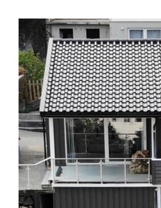 Fotografi av en bygning sett fra siden, som viser taket, fasaden, et glassveranda og en balkong.