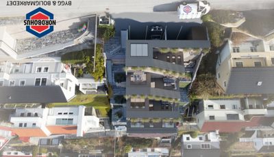 3D-visualisering av et moderne hus med terrasser og garasje, sett fra luften.