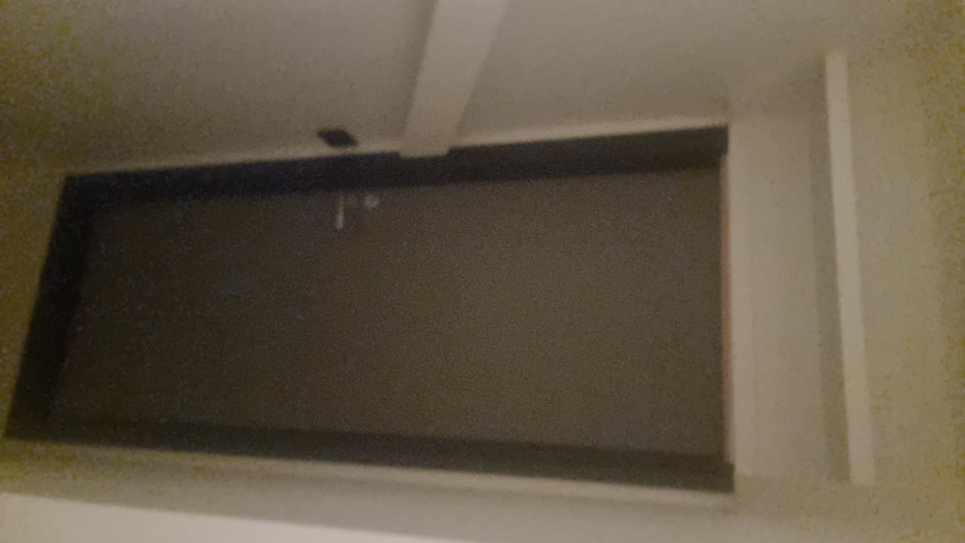 Fotografi av en dør og en del av takkonstruksjonen i et rom.