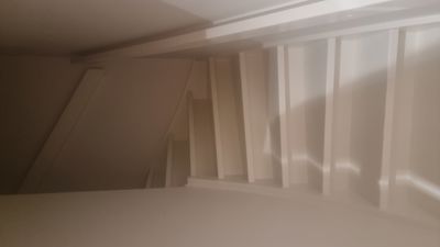 Fotografi av en trapp med hvite trinn og en hvit taklist.