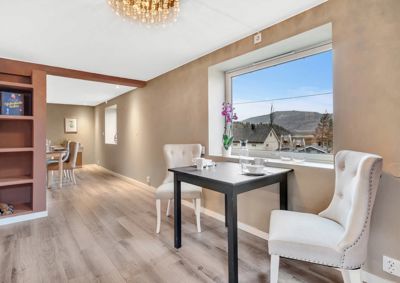 Fotografi av et innendørs rom i en bolig, sannsynligvis en spisestue eller etasje med et bord og stoler.