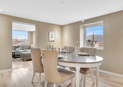 Fotografi av et innendørs rom, sannsynligvis et spisestueområde med en matbord og stoler.