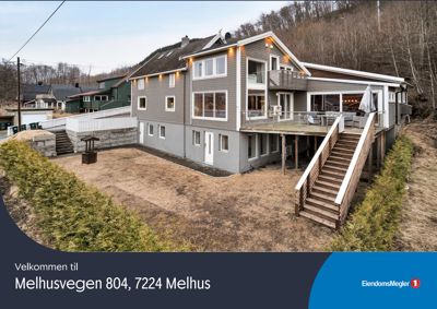 Fotografi av en moderne villa sett fra bakgårdssiden med en terrasse og trapper.