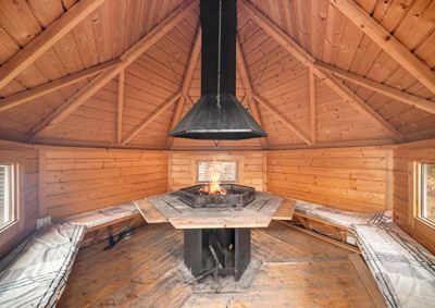 Fotografi av et interiør med en peis og trepanelvegger.