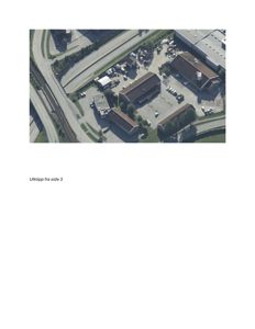 Flyfoto eller luftfoto av et industriområde med flere bygninger, veier og jernbanespor.