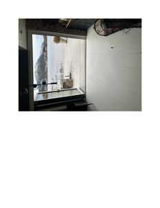 Fotografi av en innendørs utsikt mot en terrasse og fjord.