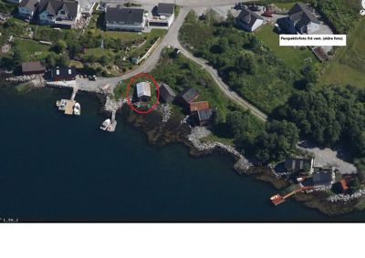 Luftfoto (satellittbilde) av et kystområde med flere hus, båter og en vei. Et hus er markert med en rød sirkel.