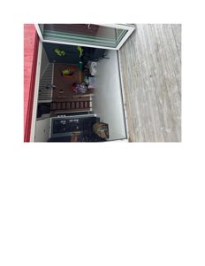 Fotografi av en uteplass eller terrasse med et åpent vindu som ser inn i et rom inne i bygningen.