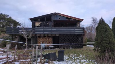 Fotografi av en skadet bygning med en delvis inntiltekt.