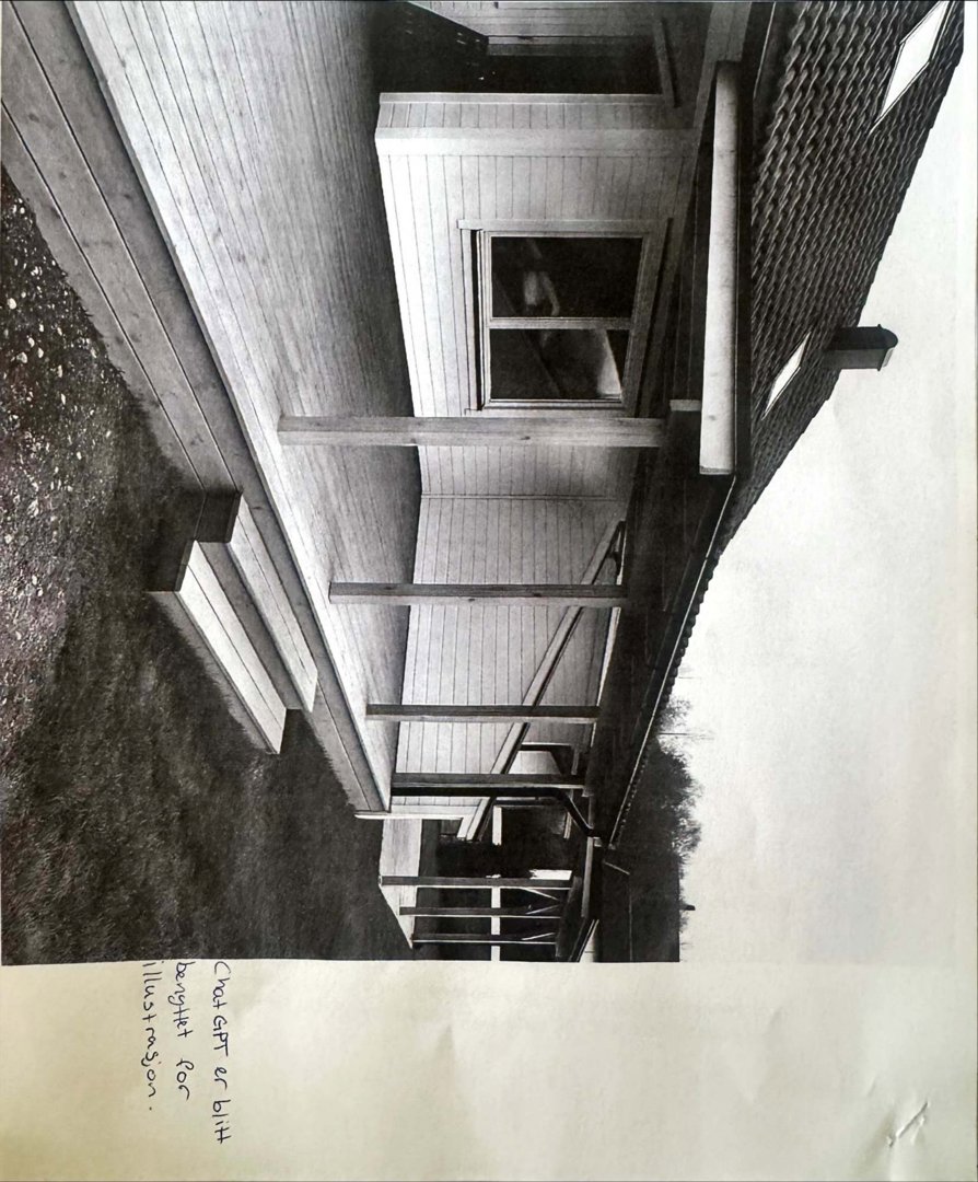 Sort-hvitt fotografi av en bygning sett fra siden, som viser en utvendig trapp, en veranda med søyler og en del av fasaden.