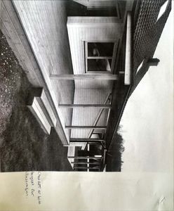 Sort-hvitt fotografi av en bygning sett fra siden, som viser en utvendig trapp, en veranda med søyler og en del av fasaden.