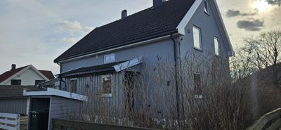 Fotografi av en grå fargefarget bolig sett fra siden.