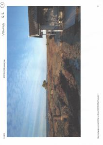 Fotografi av en bygning sett fra utsiden, med omgivende terreng og himmel.