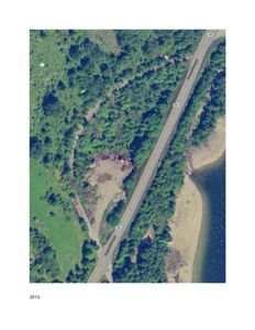 Flyfoto eller satellittbilde av et område med skog, en vei og vann, med årstall 2013 nederst.