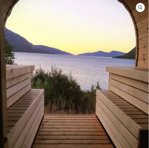 Fotografi av en utsikt fra en terrasse eller veranda mot et vann og fjell.