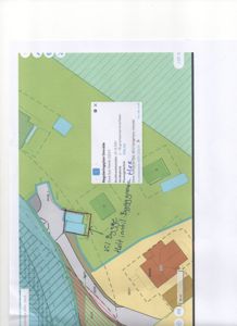 En digital situasjonsplan eller kartutsnitt (sannsynligvis fra Google Maps) som viser et grunntomteforhold med bygningsfot, vegnett og arealbruk. Det er håndskrevne notater om 'V21 Bygge' og en popup-vindu med detaljer om eiendommen.