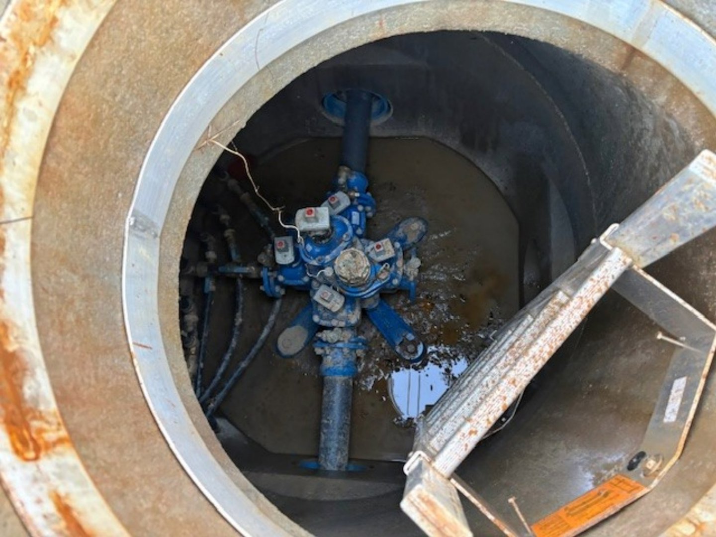 Fotografi av en teknisk utstyr i en brønn eller tank, sannsynligvis en vannpumpe eller ventilasjonssystem.