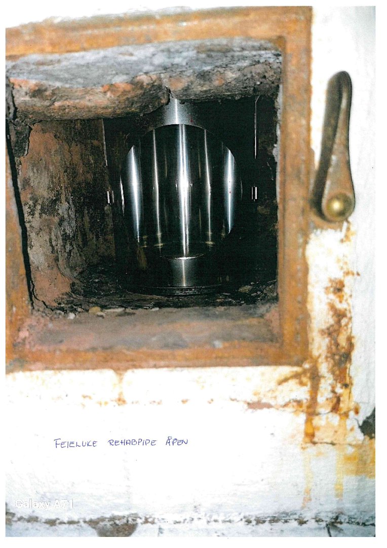 Fotografi av en åpen feieluke med en renovert renoeringsrør inne i en mur.