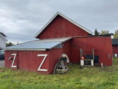 Fotografi av en rød skurebygning med hvite 'Z'-merker på dørene, sett fra siden.